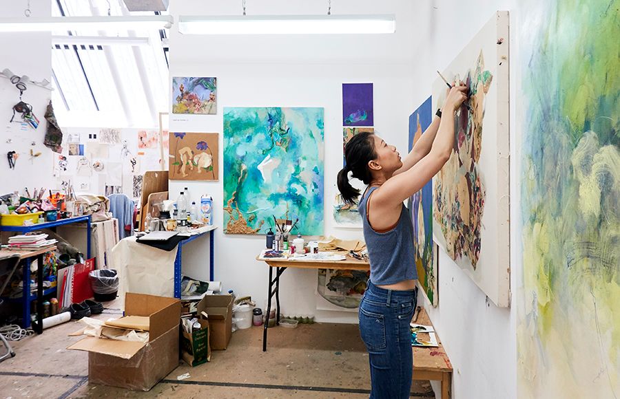 An RCA student working on a canvas, mounted on a wall